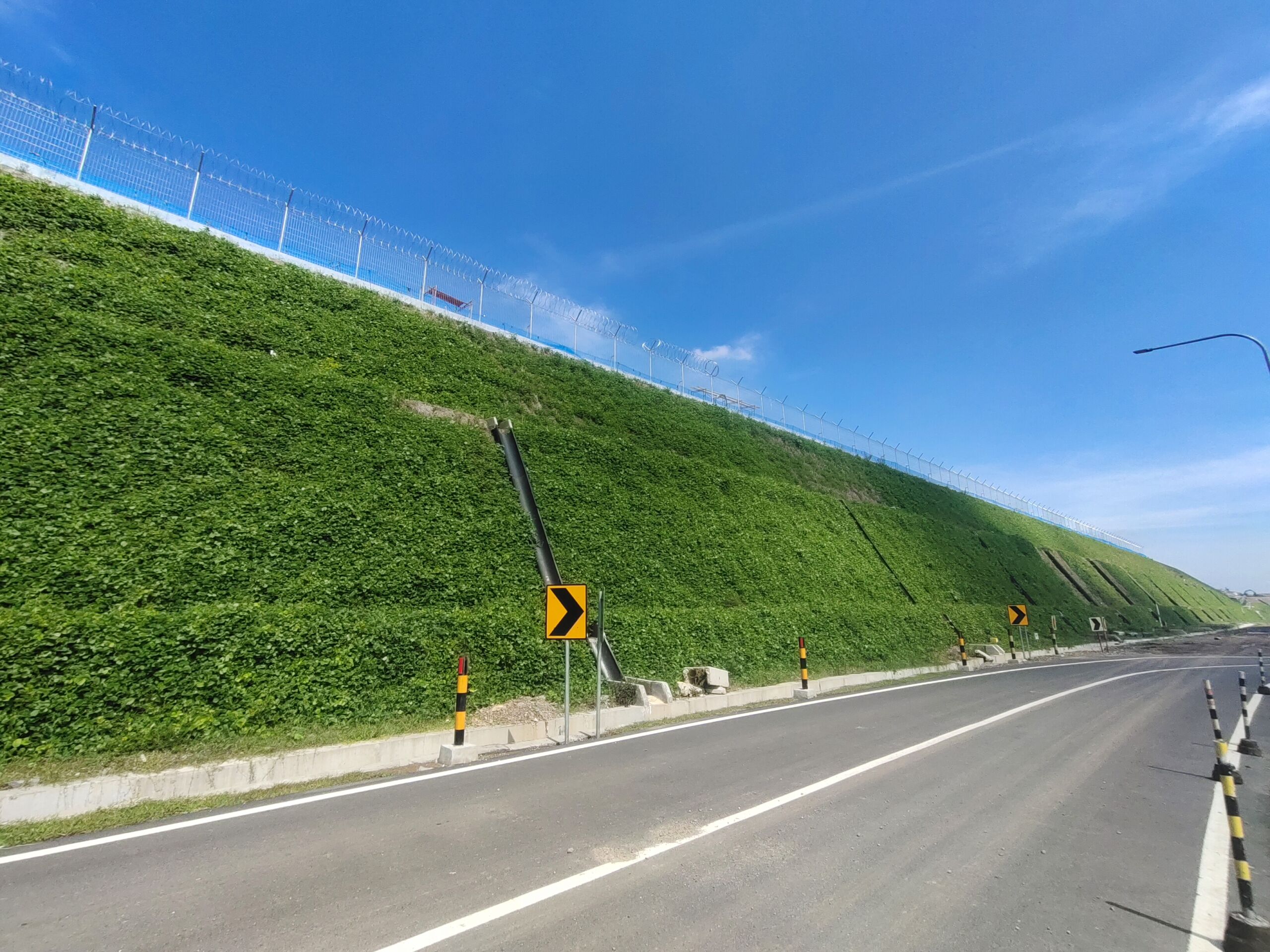 Reinforced steep slope with green vegetated facing supporting airport infrastructure, designed using Geoquest UK Geosynthetic reinforcement solutions