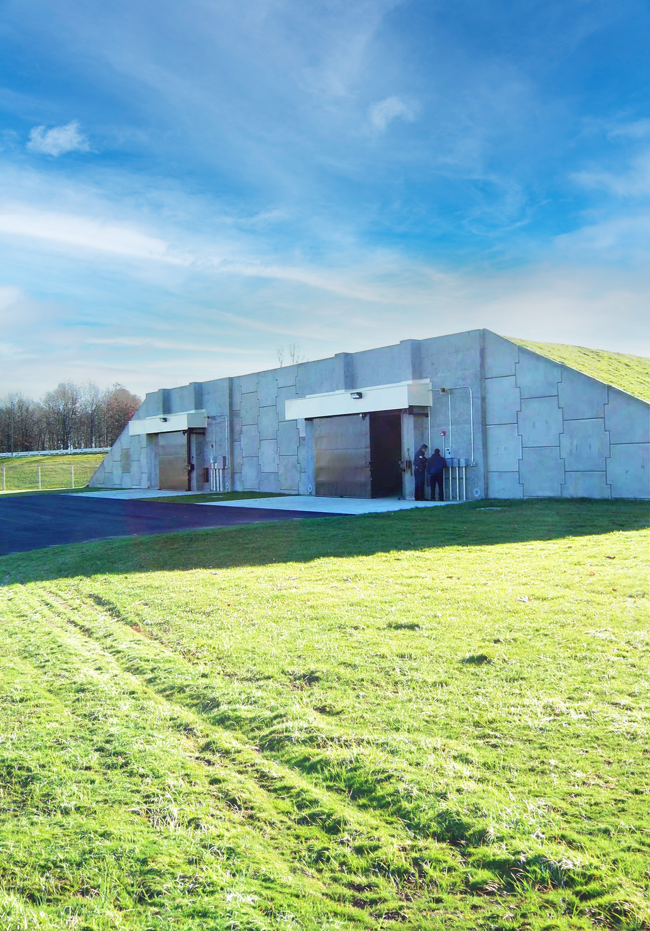 Precast concrete earth‑covered storage structure forming resilient defence estate infrastructure